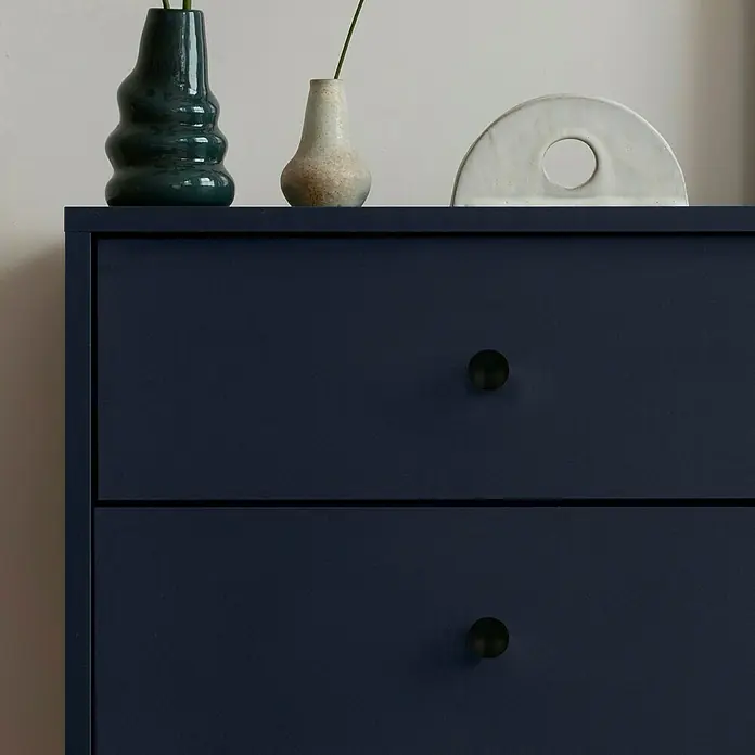Häfele Pomo para muebles - Tipo de tirador del mueble: Botón, Ø x Al: 20 x 31 mm, Negro - Primer plano de una cómoda azul marino con dos cajones, adornada con jarrones elegantes y una pieza decorativa moderna.