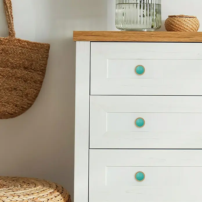 Häfele Pomo para muebles - Tipo de tirador del mueble: Botón, Ø x Al: 50 x 19,5 mm, Madera, Lacado, Turquesa, Haya - Primer plano de una cómoda blanca con tres cajones y unos tiradores redondos de color turquesa con borde decorativo.