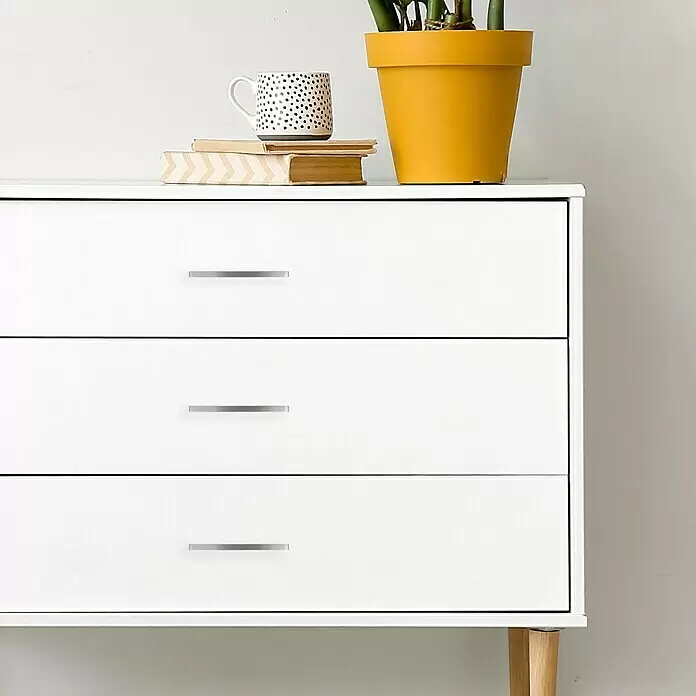 Häfele Tirador para muebles - Tipo de tirador del mueble: Estribo, L x An x Al: 158 x 24 x 10 mm, Acero inoxidable - Cómoda blanca de tres cajones con tiradores plateados y patas de madera clara.