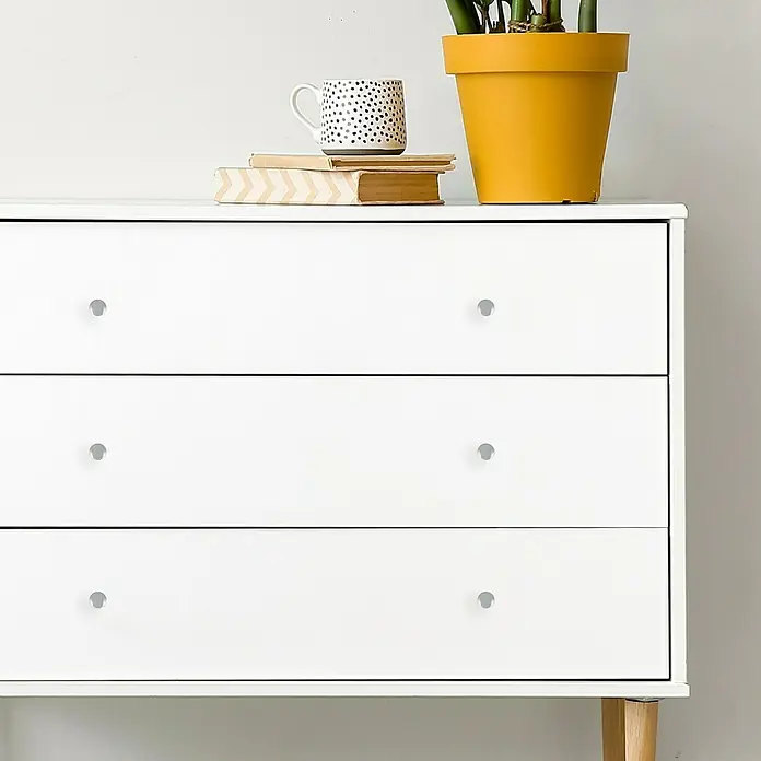 Häfele Möbelknopf - Typ Möbelgriff: Knopf, Ø x H: 20 x 31 mm, Silber - Diese Aufnahme zeigt eine weiße Kommode mit drei Schubladen und silbernen Knöpfen, die eine stilvolle Ergänzung für jeden Raum darstellt.