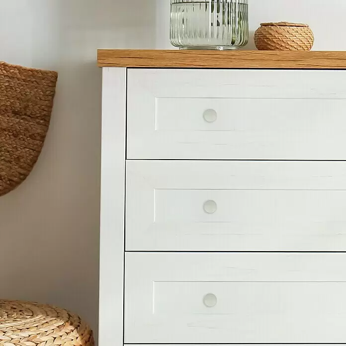 Häfele Pomo para muebles - Tipo de tirador del mueble: Botón, Ø x Al: 20 x 31 mm, Blanco - Cómoda blanca con tapa de madera natural y tres cajones, cada uno con un pomo claro, con objetos decorativos encima.
