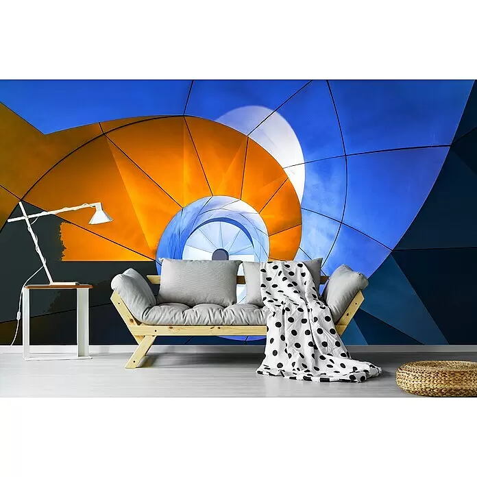Papermoon Premium collection Fototapete Schneckenstreppe - B x H: 500 x 280 cm, Vlies - Ein hölzernes Futonsofa mit grauen Kissen und einer gepunkteten Decke in einem modernen Raum mit abstrakter blau-orange Wandmalerei.