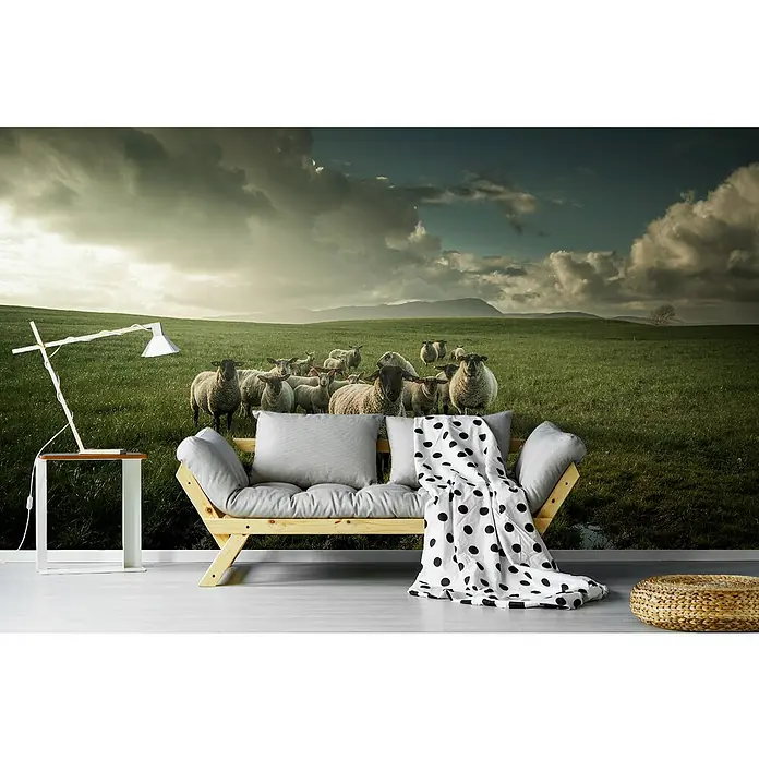 Papermoon Premium collection Fototapete Schaf - B x H: 250 x 186 cm, Vlies - Wohnzimmer-Interieur mit einem Sofa mit Schaf-Tapete, Lampe und einem Polka-Dot-Überwurf. Die Tapete dominiert den Raum.