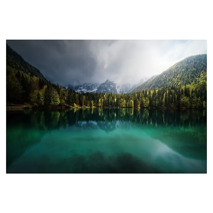 Papermoon Premium collection Fototapete Bergsee Wetterumschwung - B x H: 250 x 186 cm, Vlies - Malerischer See mit smaragdgrünem Wasser, umgeben von dichtem Wald und schneebedeckten Bergen unter bewölktem Himmel. Die Reflexion verstärkt die Schönheit.