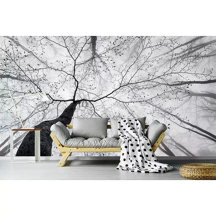 Papermoon Premium collection Fototapete Waldblick nach oben - B x H: 250 x 186 cm, Vlies - Ein helles Futonsofa aus Holz mit grauen Kissen und gepunkteter Decke in einem modernen Wohnzimmer.