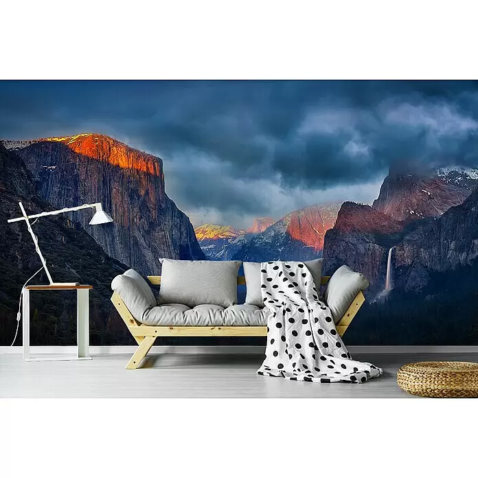 Papermoon Premium collection Fototapete Yin Yang Yosemit - B x H: 350 x 260 cm, Vlies - Helles Holzsofa mit grauen Kissen und gepunkteter Decke in einem Zimmer mit Bergwandbild.