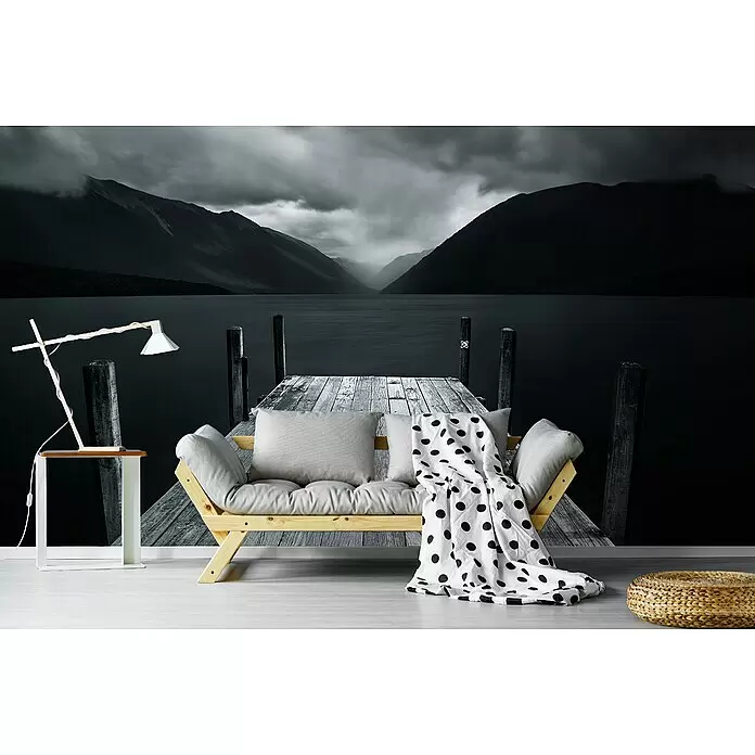 Papermoon Premium collection Fototapete Der See - B x H: 500 x 280 cm, Vlies - Helles Futonsofa aus Holz mit grauen Kissen, gepunkteter Decke, weißem Beistelltisch mit Lampe und geflochtenem Pouf.