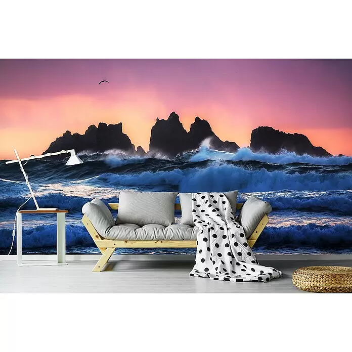 Papermoon Premium collection Fototapete Bandon Strandschichten - B x H: 450 x 280 cm, Vlies - Graues Futonsofa mit hellem Holzrahmen, verziert mit weißer Pünktchendecke, in einem Zimmer mit Ozean-Wandgemälde.