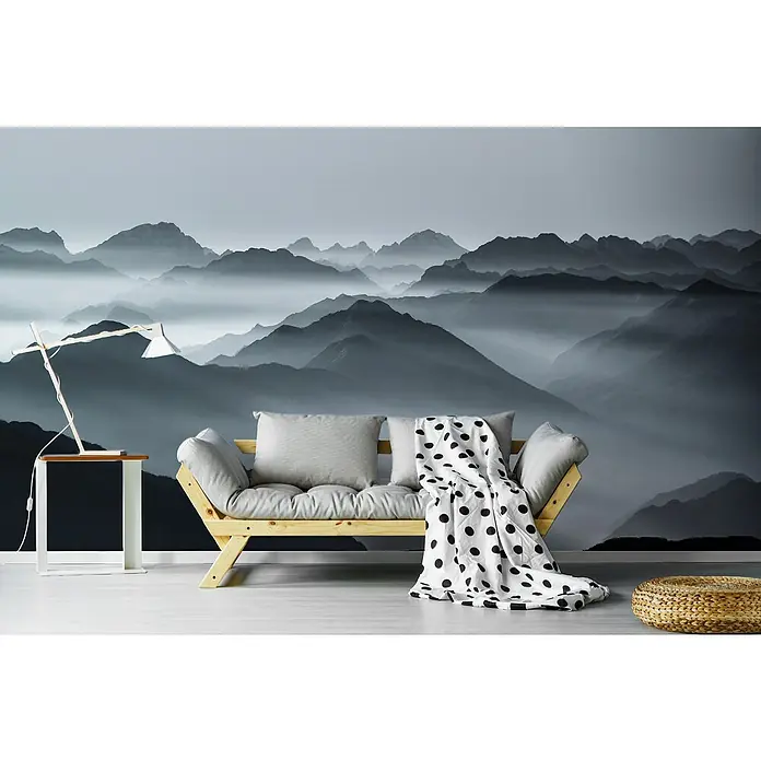 Papermoon Premium collection Fototapete Bergschichten - B x H: 250 x 186 cm, Vlies - Stilvolles Wohnzimmer mit einem hellen Sofa mit Kissen und einer Decke mit schwarzen Punkten vor einer Bergkulisse als Wandbild.