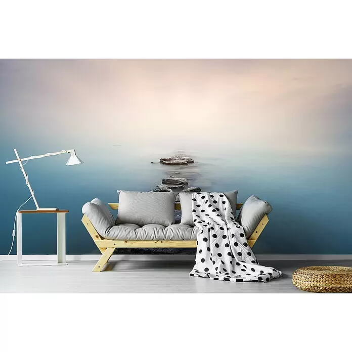 Papermoon Premium collection Fototapete Steine - B x H: 450 x 280 cm, Vlies - Wandtapete mit einer ruhigen, nebligen Meereslandschaft und Trittsteinen, die ein modernes Zimmer mit einem hellen Holzsofa akzentuiert.