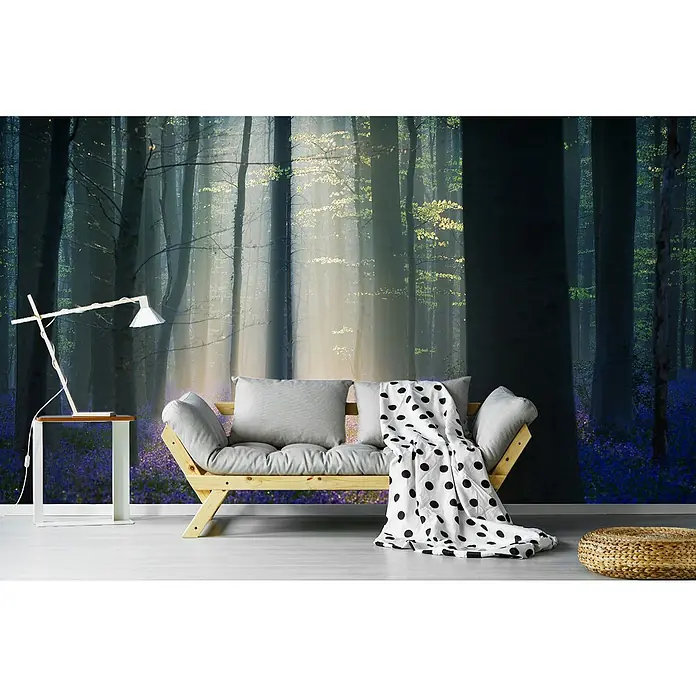 Papermoon Premium collection Fototapete Samtlicht - B x H: 300 x 223 cm, Vlies - Interieur mit einem hellen Holzsofa mit grauem Kissen und einer schwarz-weiss gepunkteten Decke vor einem Wandbild eines Waldes.