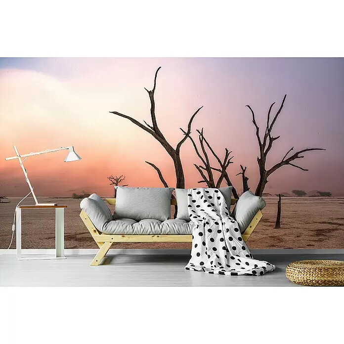Papermoon Premium collection Fototapete Nebel In Deadvlei - B x H: 350 x 260 cm, Vlies - Holz-Futonsofa mit grauen Kissen und gepunkteter Decke, dazu ein weißer Beistelltisch mit Lampe und ein geflochtener Pouf.