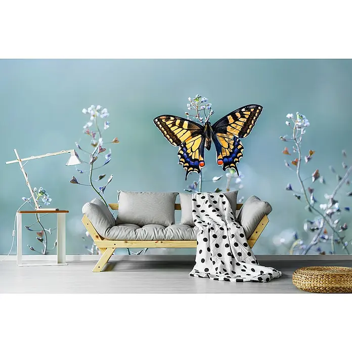 Papermoon Premium collection Fototapete Swallowtailbeauty - B x H: 300 x 223 cm, Vlies - Ein gemütliches Wohnzimmer mit einem hellen Holzsofa, grauen Kissen und einer Decke mit schwarzen Punkten vor einer Wand mit Schmetterlingsmotiv.