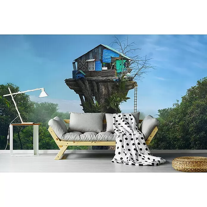 Papermoon Premium collection Fototapete Haus am Himmel - B x H: 250 x 186 cm, Vlies - Helles Holzsofa mit grauen Kissen und gepunkteter Decke in einem Raum mit Dschungelwandbild.