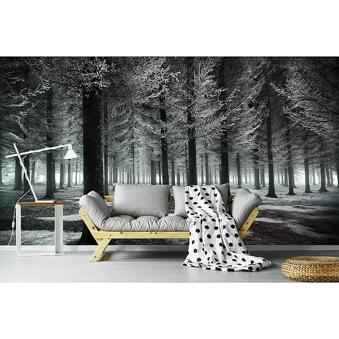 Papermoon Premium collection Fototapete Beginn des Winters - B x H: 500 x 280 cm, Vlies - Holzsofa mit hellgrauen Kissen und weißer Tupfen-Decke vor einer Wandtapete mit gefrostetem Wald in einem modernen Wohnraum.