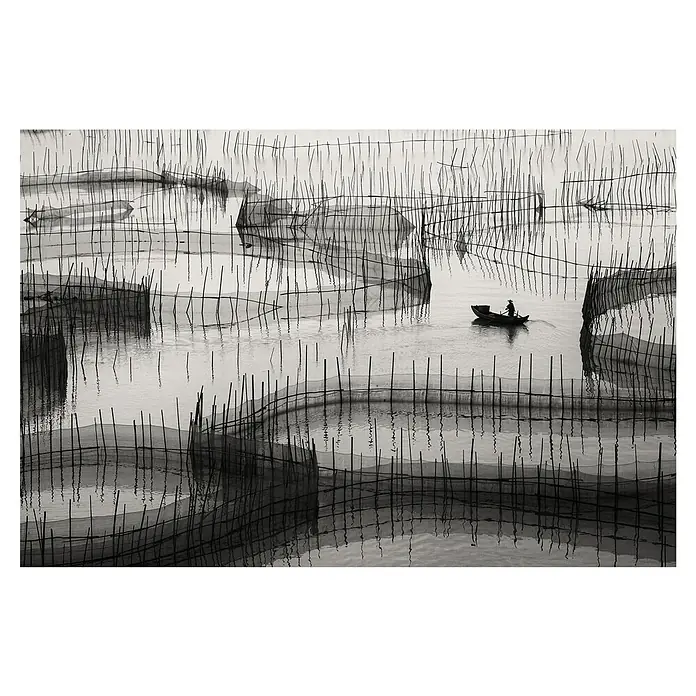 Papermoon Premium collection Fototapete Warten auf den Haken - B x H: 500 x 280 cm, Vlies - Fischerboot inmitten von Fischernetzen, eine ruhige Schwarzweißaufnahme, die die Einfachheit und das traditionelle Handwerk betont.