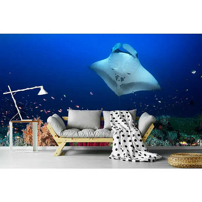 Papermoon Premium collection Fototapete Ocean Mantaray Riff - B x H: 400 x 260 cm, Vlies - Wohnzimmer-Deko-Idee mit einem stilvollen Sofa, einer Lampe und einem Hocker vor einer Unterwasser-Fototapete mit einem Mantarochen.