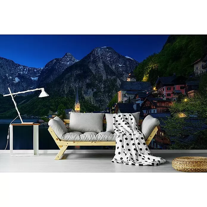 Papermoon Premium collection Fototapete Touristenansicht - B x H: 250 x 186 cm, Vlies - Helles Holzsofa mit grauen Kissen und gepunkteter Decke in einem Wohnzimmer, daneben weiße Lampe und Strohhocker.