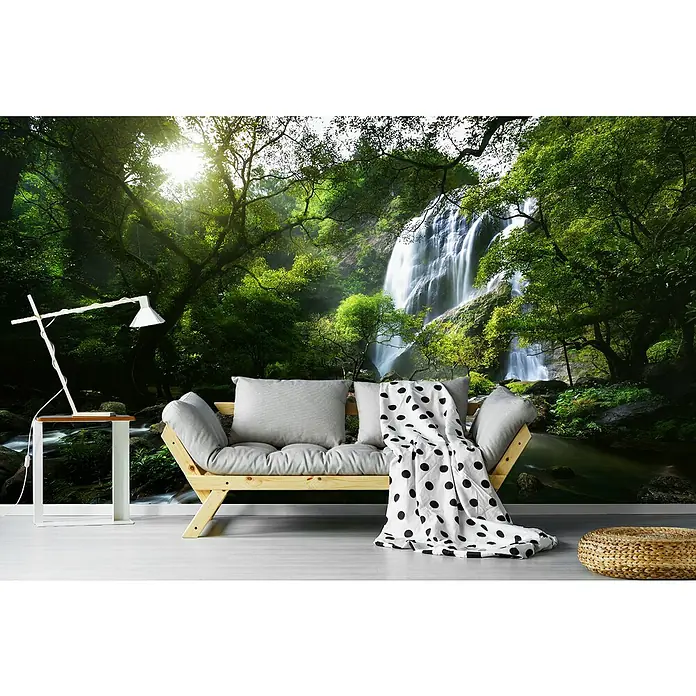 Papermoon Premium collection Fototapete Gebirgsbach - B x H: 400 x 260 cm, Vlies - Wohnzimmer mit einem hellen Sofa, Tischlampe und einem Hocker, vor einer Fototapete mit Wasserfallmotiv.