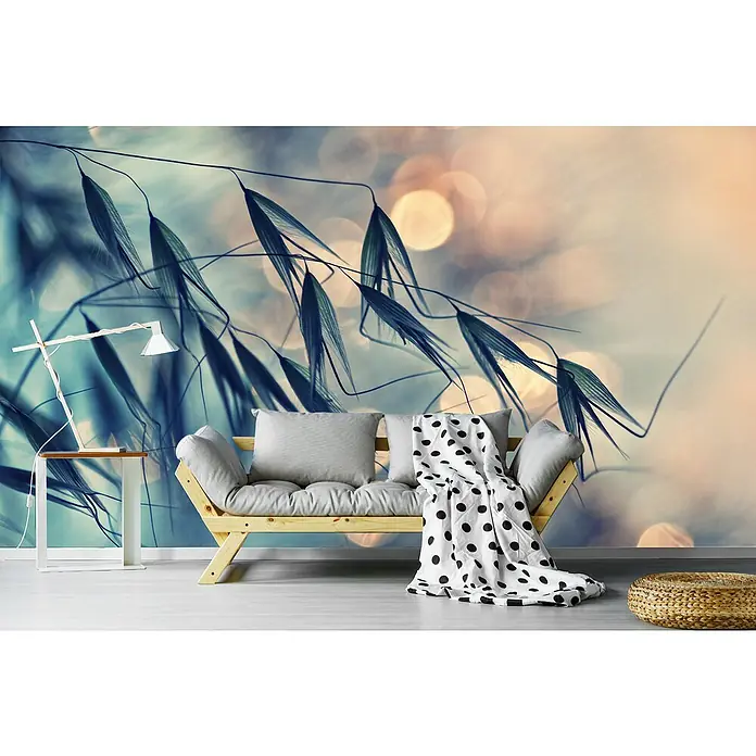 Papermoon Premium collection Fototapete Gräser Gegenlicht - B x H: 400 x 260 cm, Vlies - Gemütliches Wohnzimmer mit modernem Sofa, Zierkissen und einer Decke mit Punktmuster. Ein stilvoller Hocker aus Rattan rundet das Gesamtbild ab.