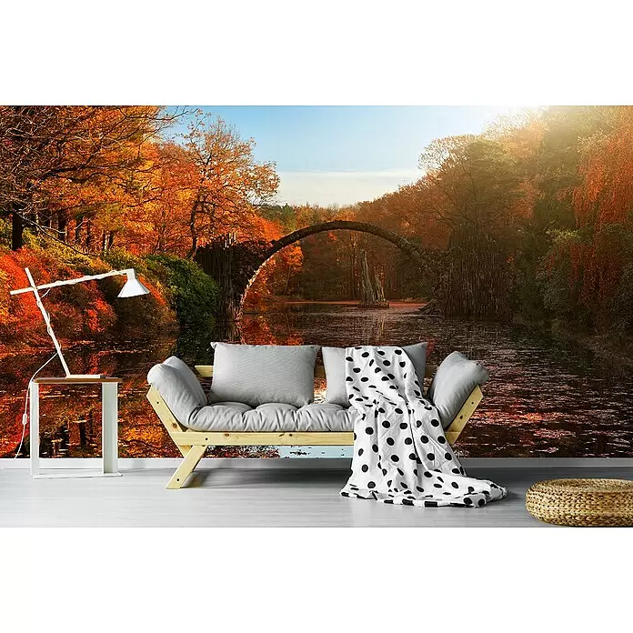 Papermoon Premium collection Fototapete Herbstsee - B x H: 300 x 223 cm, Vlies - Ein gemütlicher Wohnraum mit einem hellen Holzsofa, grauen Kissen, einer gepunkteten Decke, einem weißen Beistelltisch mit Lampe und einem gewebten Pouf.