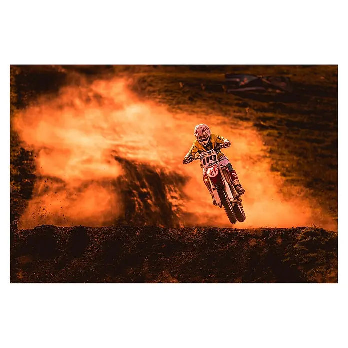 Papermoon Premium collection Fototapete Glühende Motorradstrecke - B x H: 250 x 186 cm, Vlies - Ein Motocross-Fahrer mit gelbem Trikot und der Nummer 119 springt mit seinem roten Motorrad über eine Erhebung.