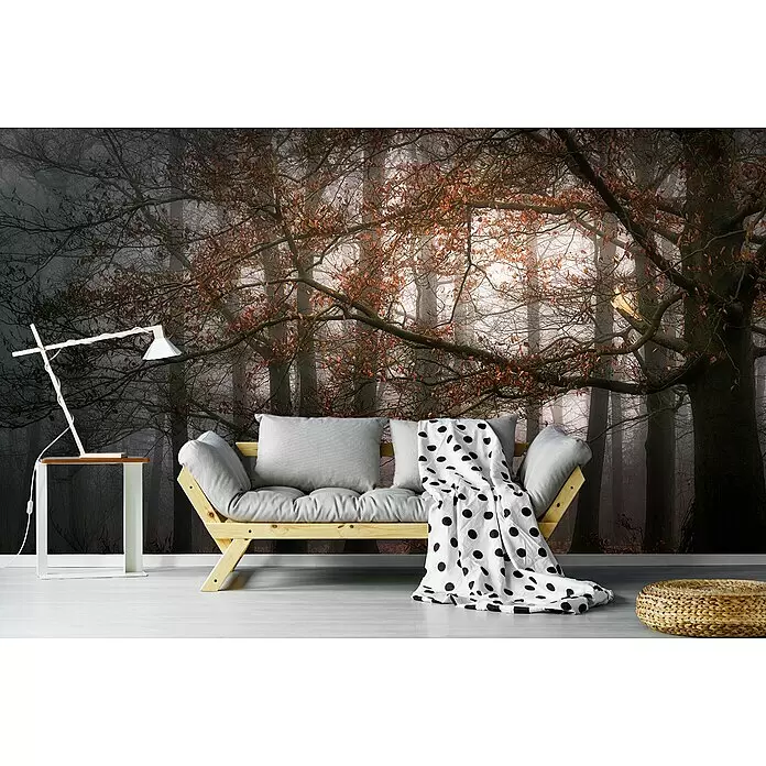 Papermoon Premium collection Fototapete Mystische Waldaura - B x H: 250 x 186 cm, Vlies - Gemütlicher Wohnraum mit Holzsofa, grauen Kissen, weißem Beistelltisch und gewebtem Pouf vor einem Waldwandbild.