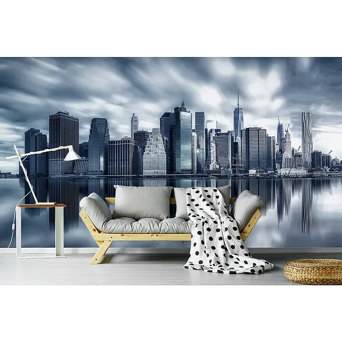 Papermoon Premium collection Fototapete Manhattanreflexion - B x H: 300 x 223 cm, Vlies - Helles Wohnzimmer mit modernem Holzsofa, grauem Kissen, einer Decke mit schwarzen Punkten und einem Tisch mit Lampe vor einer New Yorker Skyline Tapete.