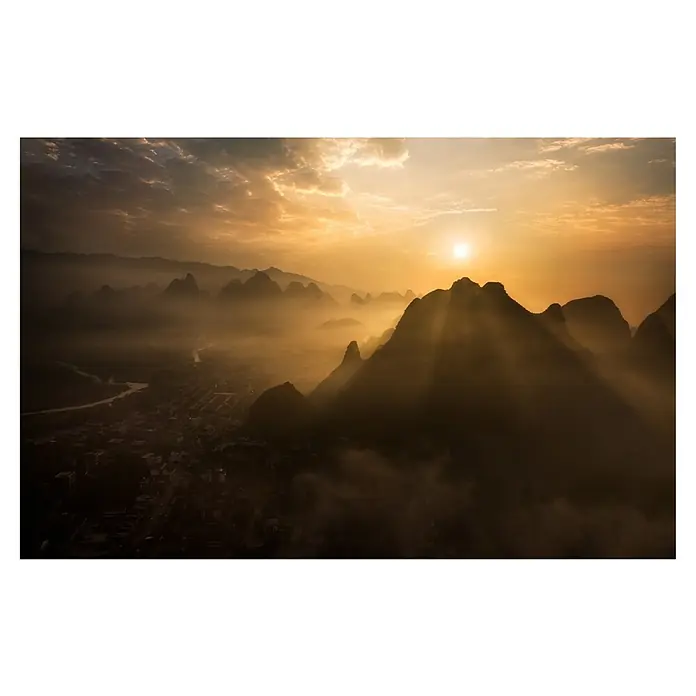 Papermoon Premium collection Fototapete Nebliger Sonnenaufgang - B x H: 450 x 280 cm, Vlies - Morgendliche Landschaft mit Bergen und Nebel, die von der aufgehenden Sonne in goldenes Licht getaucht werden. Die Szenerie strahlt Ruhe und Erhabenheit aus.
