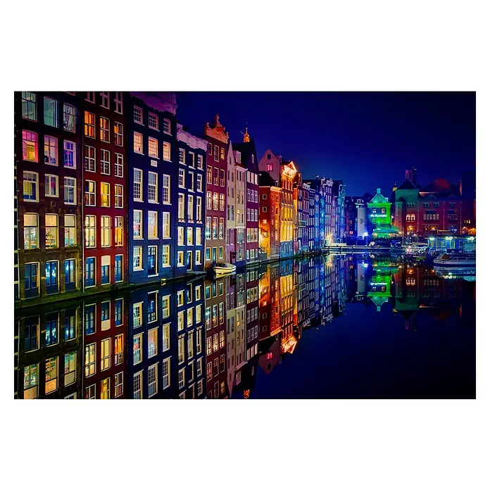 Papermoon Premium collection Fototapete Amsterdam - B x H: 250 x 186 cm, Vlies - Das farbenfrohe Amsterdam bei Nacht: Gebäude und ihre Spiegelbilder im Wasser erstrahlen in lebendigen Farben, ein malerischer Anblick.