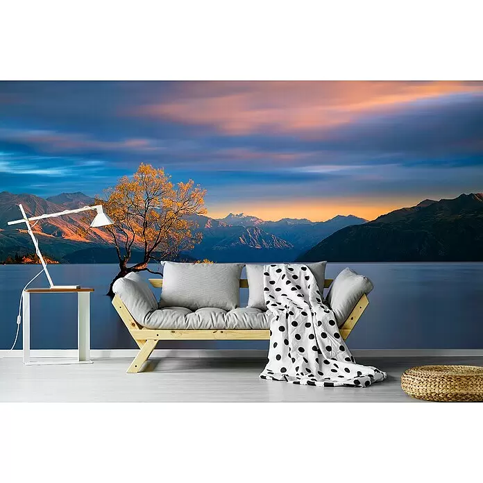 Papermoon Premium collection Fototapete Morgensglühen - B x H: 500 x 280 cm, Vlies - Helles Futonsofa aus Holz mit hellgrauen Kissen und einer weiß-gepunkteten Decke.