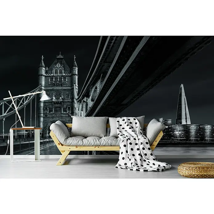 Papermoon Premium collection Fototapete London-Skyline - B x H: 400 x 260 cm, Vlies - Eine moderne Couch mit grauem Kissen und einer schwarz-weißen Decke mit Punkten, vor einer stilvollen Fototapete von London.