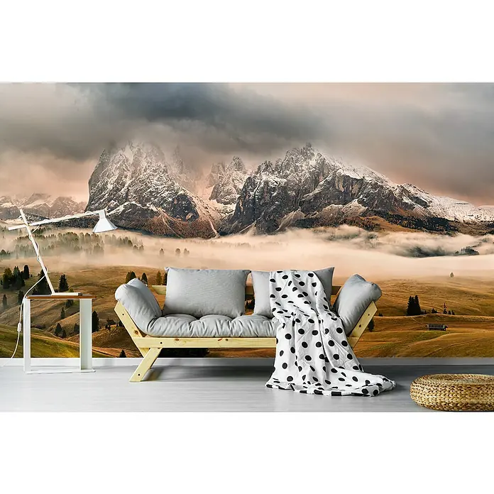 Papermoon Premium collection Fototapete Dolomiten Mythen - B x H: 450 x 280 cm, Vlies - Dieses Bild zeigt ein stilvolles Sofa mit Kissen und Decke in einem Raum mit Berg-Tapete. Das Sofa und die Dekorationen schaffen eine gemütliche Atmosphäre.