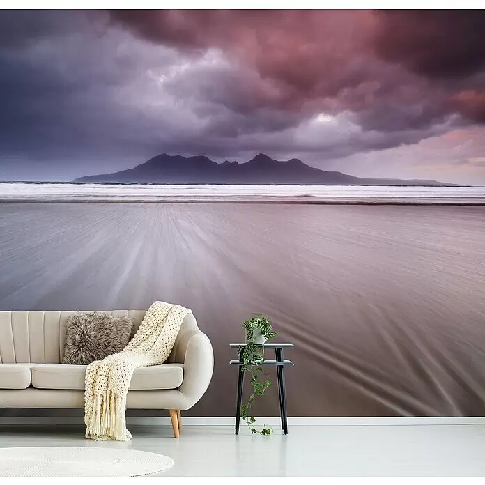 Papermoon Premium collection Fototapete Berge, Sand und Wolken - B x H: 350 x 260 cm, Vlies - Wandtapete mit Langzeitbelichtungs-Strandszene, dunklen Bergen und dramatischen rosa-violetten Wolken als lebendiger Blickfang in einem modernen Raum.