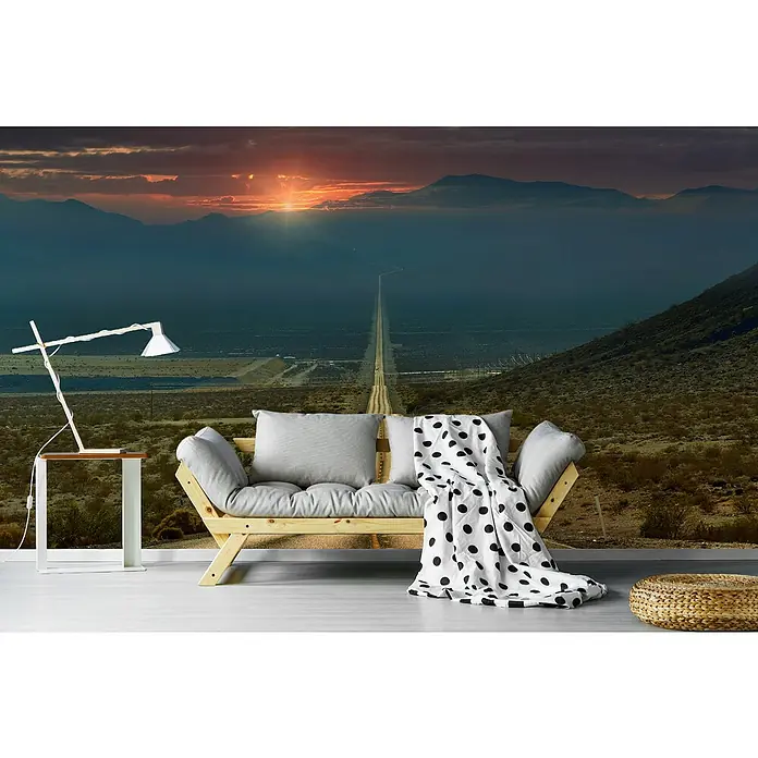 Papermoon Premium collection Fototapete Higway - B x H: 250 x 186 cm, Vlies - Stilvolles Wohnzimmer mit einer Fototapete, die eine endlose Straße in der Wüste bei Sonnenuntergang zeigt, Couch und Beistelltisch mit Lampe.