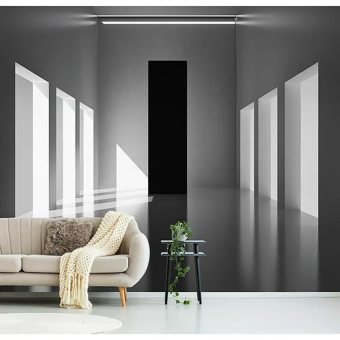 Papermoon Premium collection Fototapete Licht und Dimension - B x H: 300 x 223 cm, Vlies - Das Bild zeigt ein modernes Wohnzimmer mit einem stilvollen Sofa, einem kleinen Beistelltisch mit Pflanze und einer auffälligen Wanddekoration.