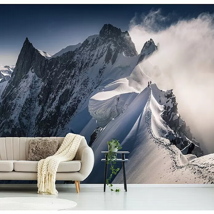 Papermoon Premium collection Fototapete Auf der Linie gehen - B x H: 450 x 280 cm, Vlies - Ein atemberaubendes Wandbild mit einem weiten schneebedeckten Gebirge und kleinen Kletterern auf einem Grat, das ein modernes Wohnzimmer verschönert.