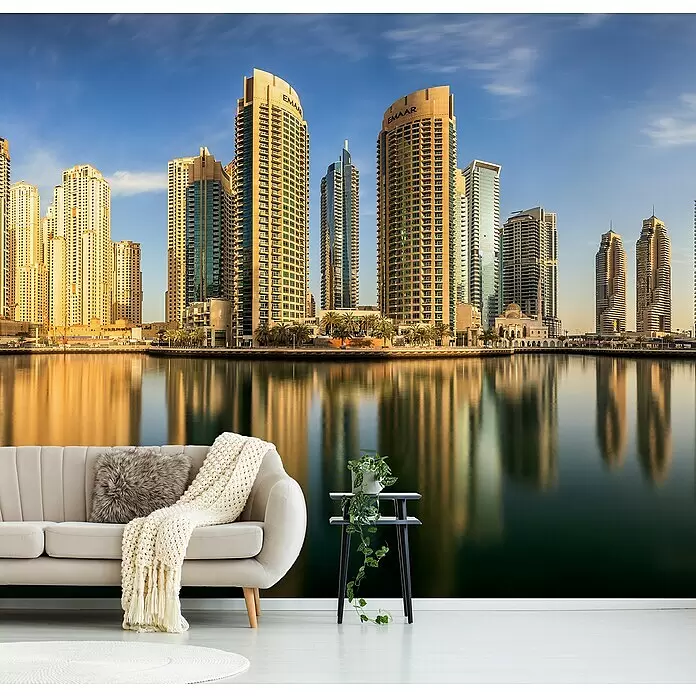 Papermoon Premium collection Fototapete Panorama Dubai Marina - B x H: 250 x 186 cm, Vlies - Wandbild mit einer Stadtkulisse bei goldener Stunde, im Wasser gespiegelt, hinter einem Sofa und einer Pflanze, für ein modernes Interieur.