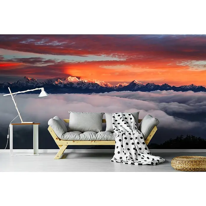Papermoon Premium collection Fototapete Die Berggötter - B x H: 450 x 280 cm, Vlies - Einrichtungsidee mit einer Couch vor einer Fototapete mit einem Bergpanorama bei Sonnenaufgang, die eine entspannende Atmosphäre schafft.