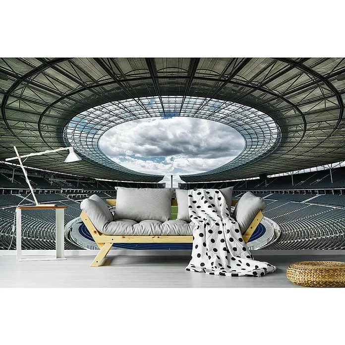 Papermoon Premium collection Fototapete Berlin - B x H: 200 x 149 cm, Vlies - Wohnraum mit modernem Sofa, Lampe und Hocker vor einer Stadion-Fototapete, die ein einzigartiges Ambiente schafft.