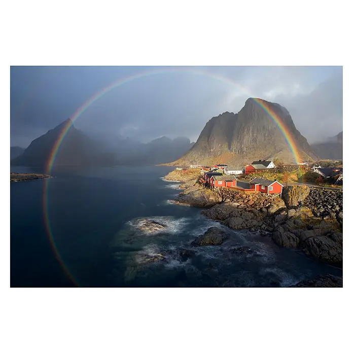 Papermoon Premium collection Fototapete Im Regenbogen - B x H: 400 x 260 cm, Vlies - Atemberaubende Landschaft mit einem farbenprächtigen Regenbogen, der über eine Küstenlinie mit roten Häusern und dramatischen Bergen führt.
