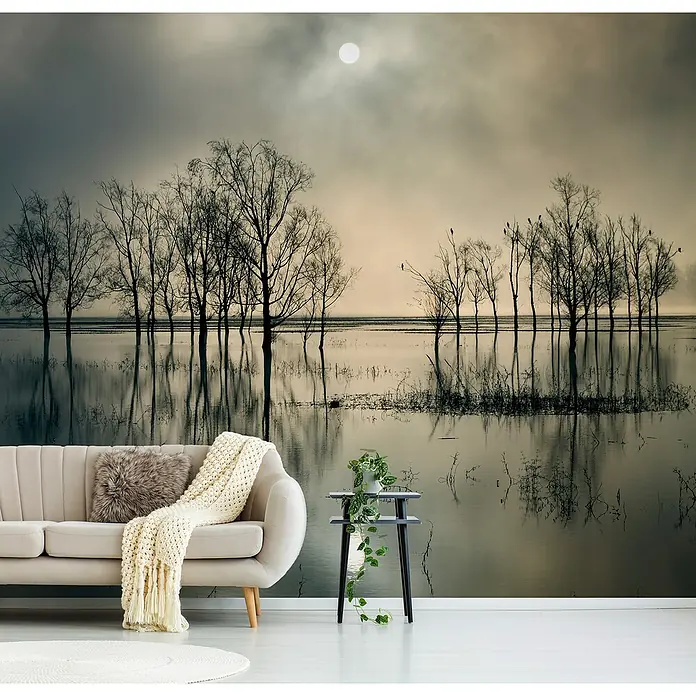 Papermoon Premium collection Fototapete Seestssee - B x H: 400 x 260 cm, Vlies - Wohnraum mit einer Couch und einem Tisch, vor einer Fototapete mit einer Landschaft von Bäumen im Wasser unter einem hellen Mond.