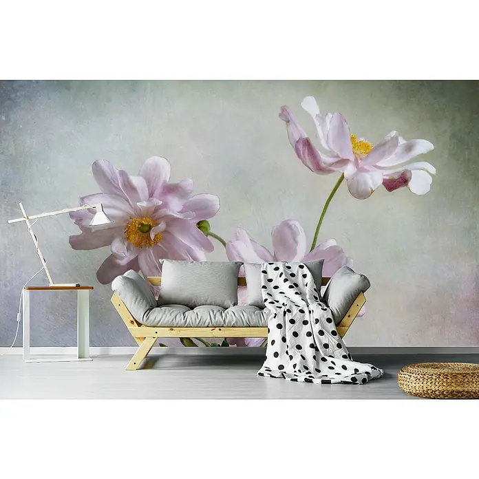 Papermoon Premium collection Fototapete Anemonen - B x H: 200 x 149 cm, Vlies - Wohnzimmer-Interieur mit einem stilvollen Holzsofa, einer Stehlampe und einem Hocker, vor einer floralen Tapete mit zarten rosa Blumen.