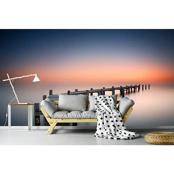 Papermoon Premium collection Fototapete Alter Pier II - B x H: 250 x 186 cm, Vlies - Ein gemütliches Sofa mit Kissen und einer Decke vor einer friedlichen Landschaft mit einem Steg.