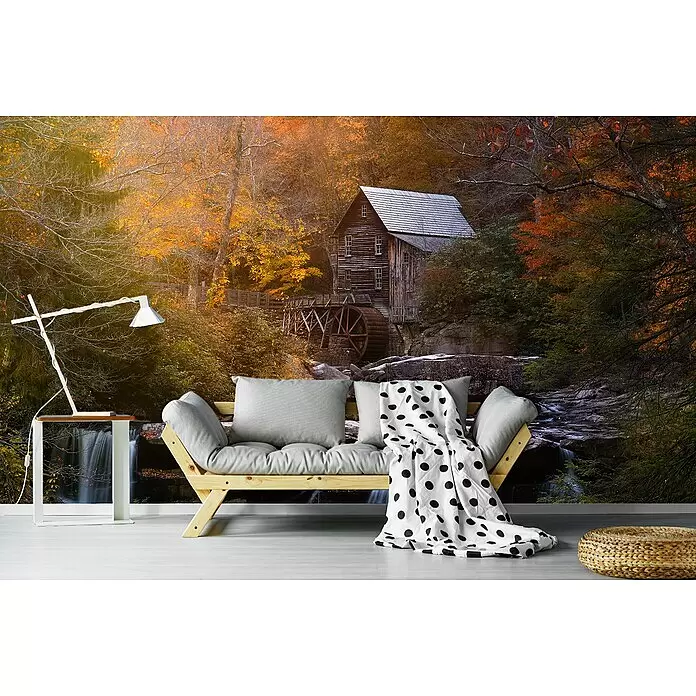 Papermoon Premium collection Fototapete Die Mühle - B x H: 250 x 186 cm, Vlies - Gemütlicher Wohnraum: helles Holzsofa mit grauen Kissen, gepunktete Decke, moderne Lampe, Beistelltisch und geflochtener Pouf. Waldwandbild im Hintergrund.