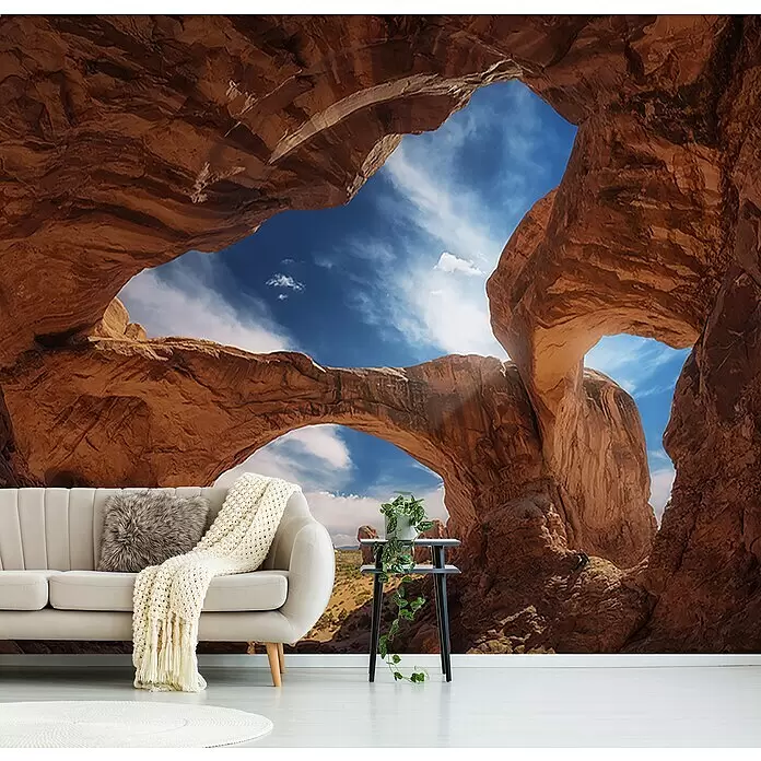 Papermoon Premium collection Fototapete Doppelbogen - B x H: 200 x 149 cm, Vlies - Wandtapete mit großen roten Felsbögen und blauem Himmel, in einem Wohnzimmer hinter einem Sofa angebracht.