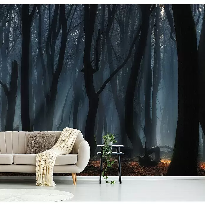 Papermoon Premium collection Fototapete Tanzbäume - B x H: 400 x 260 cm, Vlies - Ein Wohnzimmer mit beigem Sofa und einer großen Wandtapete, die einen dunklen, nebligen Wald mit kahlen Bäumen zeigt.