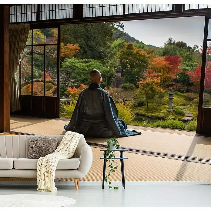 Papermoon Premium collection Fototapete Meditation - B x H: 250 x 186 cm, Vlies - Ein modernes Wohnzimmer mit hellem Sofa und Beistelltisch öffnet sich zu einem ruhigen japanischen Garten mit leuchtendem Herbstlaub und einer meditierenden Person.