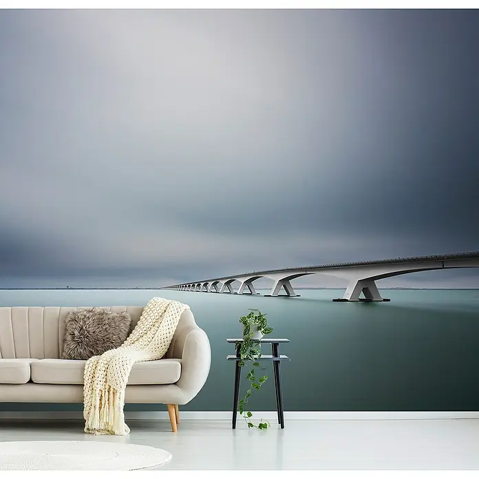 Papermoon Premium collection Fototapete Unendliche Brücke - B x H: 450 x 280 cm, Vlies - Elegante Wohnzimmerkulisse mit einem modernen Sofa, einem Beistelltisch und einer fotorealistischen Brücken-Tapete, die eine entspannende Atmosphäre schafft.