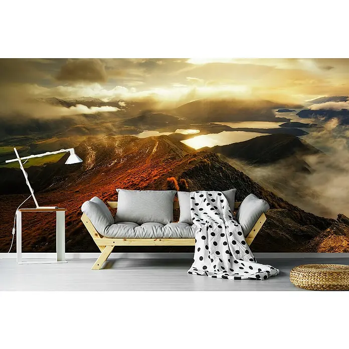 Papermoon Premium collection Fototapete Roy's Peak - B x H: 350 x 260 cm, Vlies - Wohnzimmer mit Panoramablick auf die Berge und einem bequemen Sofa mit Kissen und einer Decke.